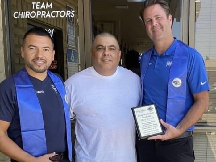 Dr. Jesús Cazares, left, and Dr. Christopher Schlenger, right, with a man in a white T-shirt outside the Premier Chiropractic office in Stockton