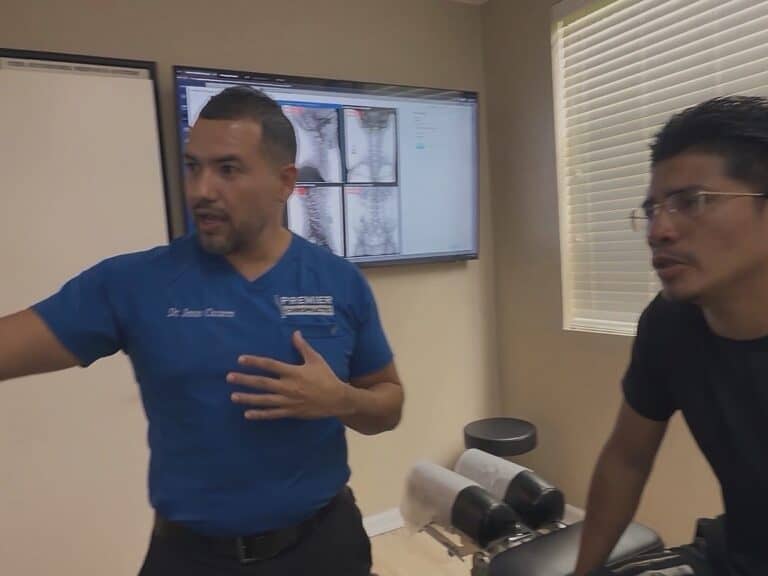 Dr. Jesús Cazares talks with a patient in an exam room at Premier Chiropractic in Stockton