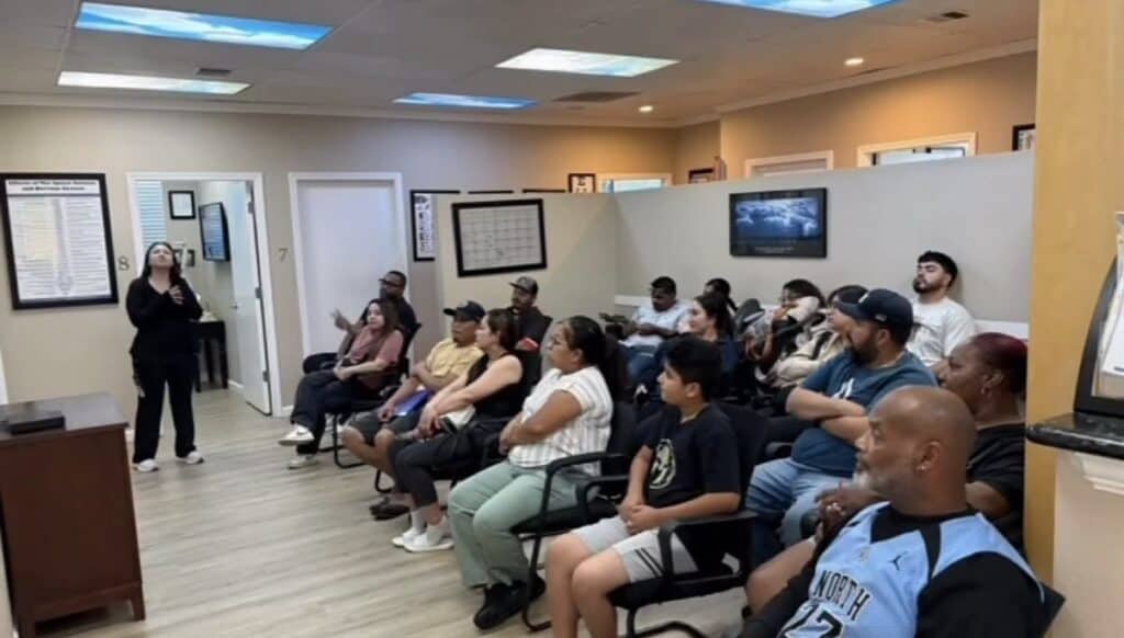 A room full of patients sits in rows during a class at Premier Chiropractic in Stockton while a woman speaks at the front